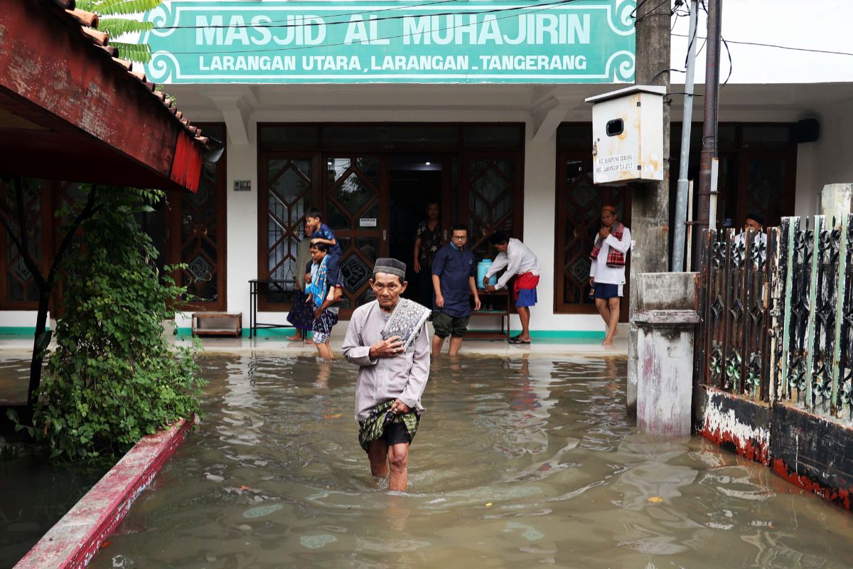Warga melewati banjir seusai melaksanakn salat Jumat di kawasan Larangan Utara, Larangan, Tangerang, Jumat