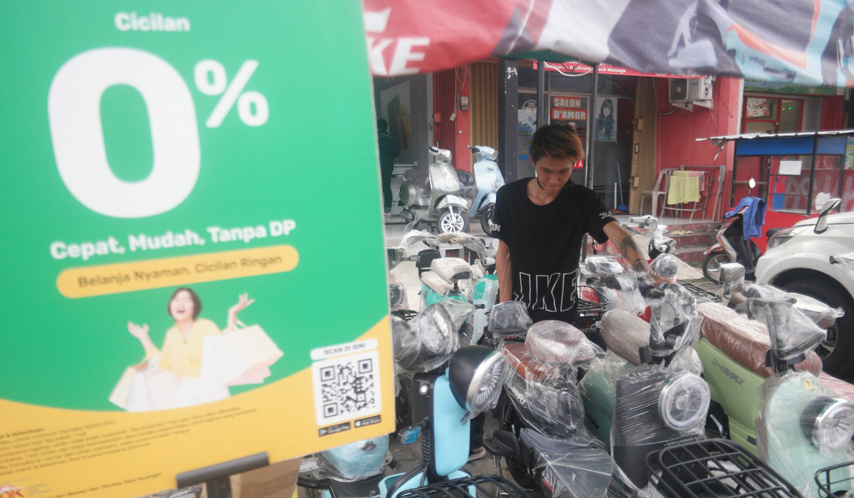 Papan promo program cicilan 0 persen dari salah satu pinjol terpampang di tempat penjualan sepeda listrik di Tangerang Selatan.
