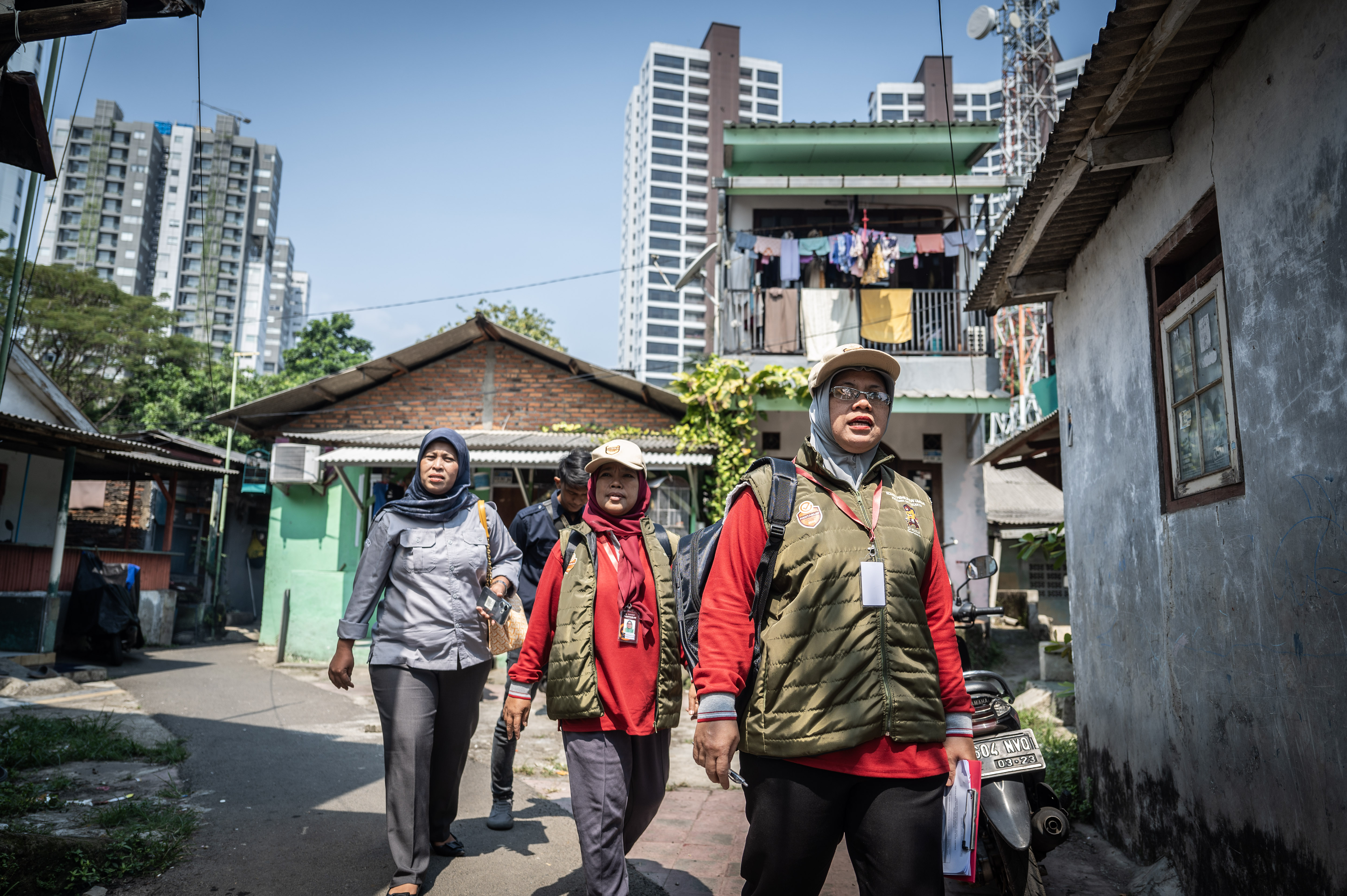 Empat petugas pemutakhiran data pemilih (Pantarlih) berjalanan menuju rumah warga untuk melakukan verifikasi data