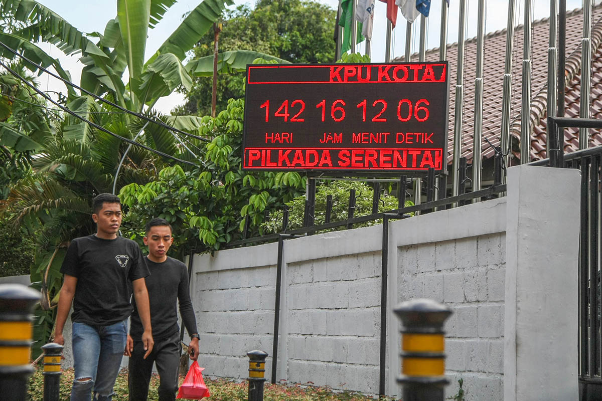 Warga melintas di dekat layar elektronik hitung mundur menuju Pilkada Serentak 2024.