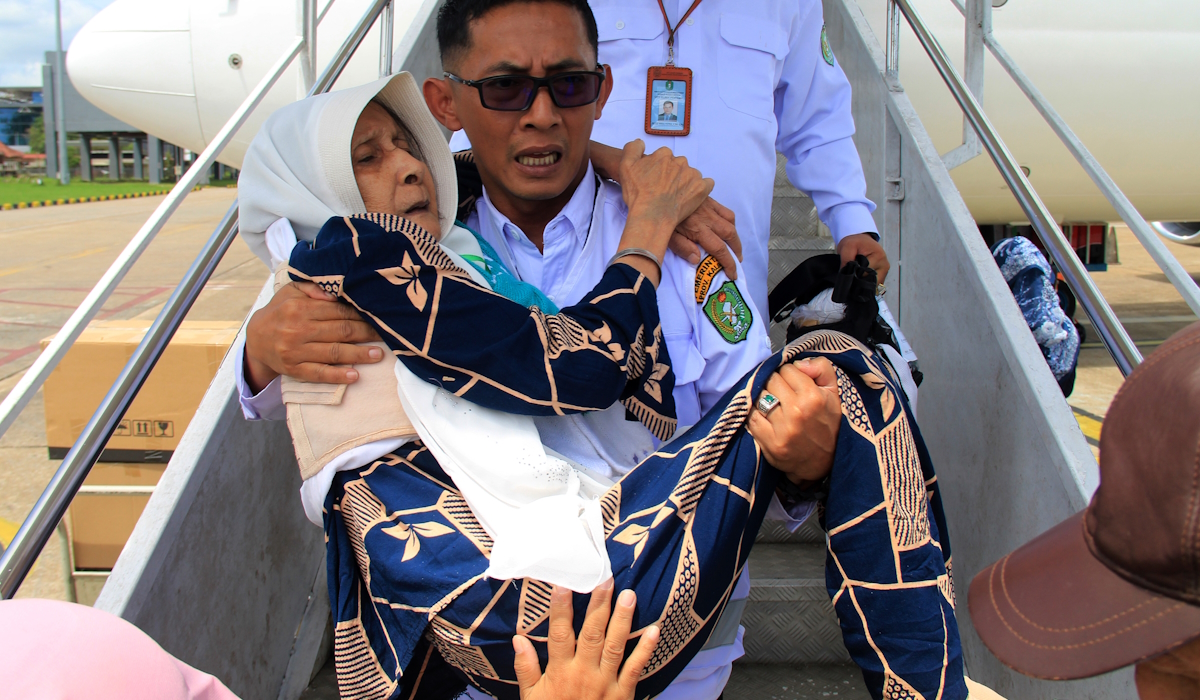 Petugas menggendong seorang jamaah haji lansia asal Kalimantan Barat saat tiba di Bandara Supadio 