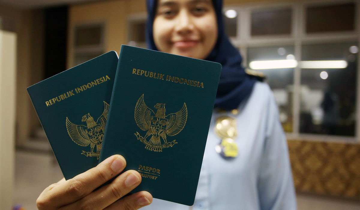 Petugas menunjukan Paspor Republik Indonesia versi desain lama.
