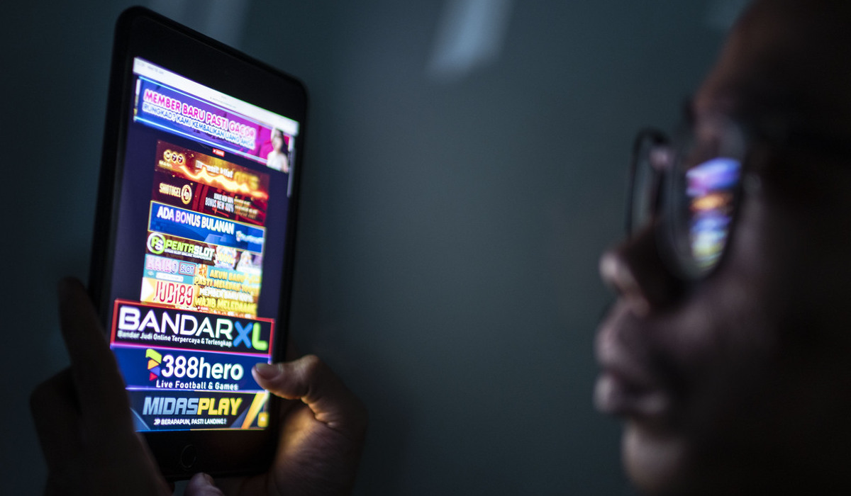 Ilustrasi, Warga melihat iklan judi online melalui gawainya.