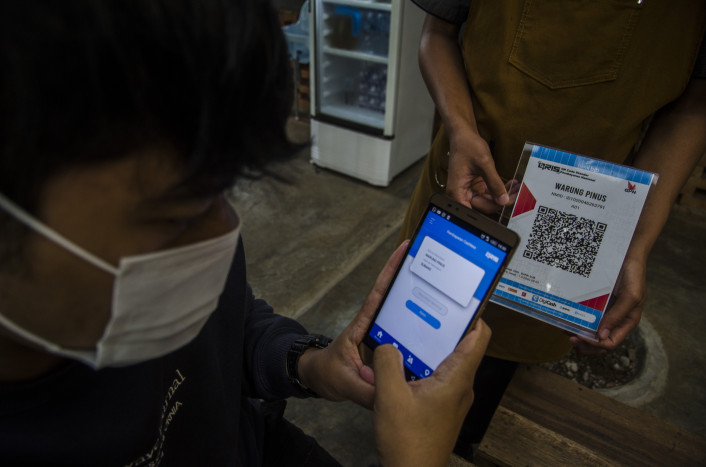 Konsuemen melakukan pembayaran dengan uang digital. 