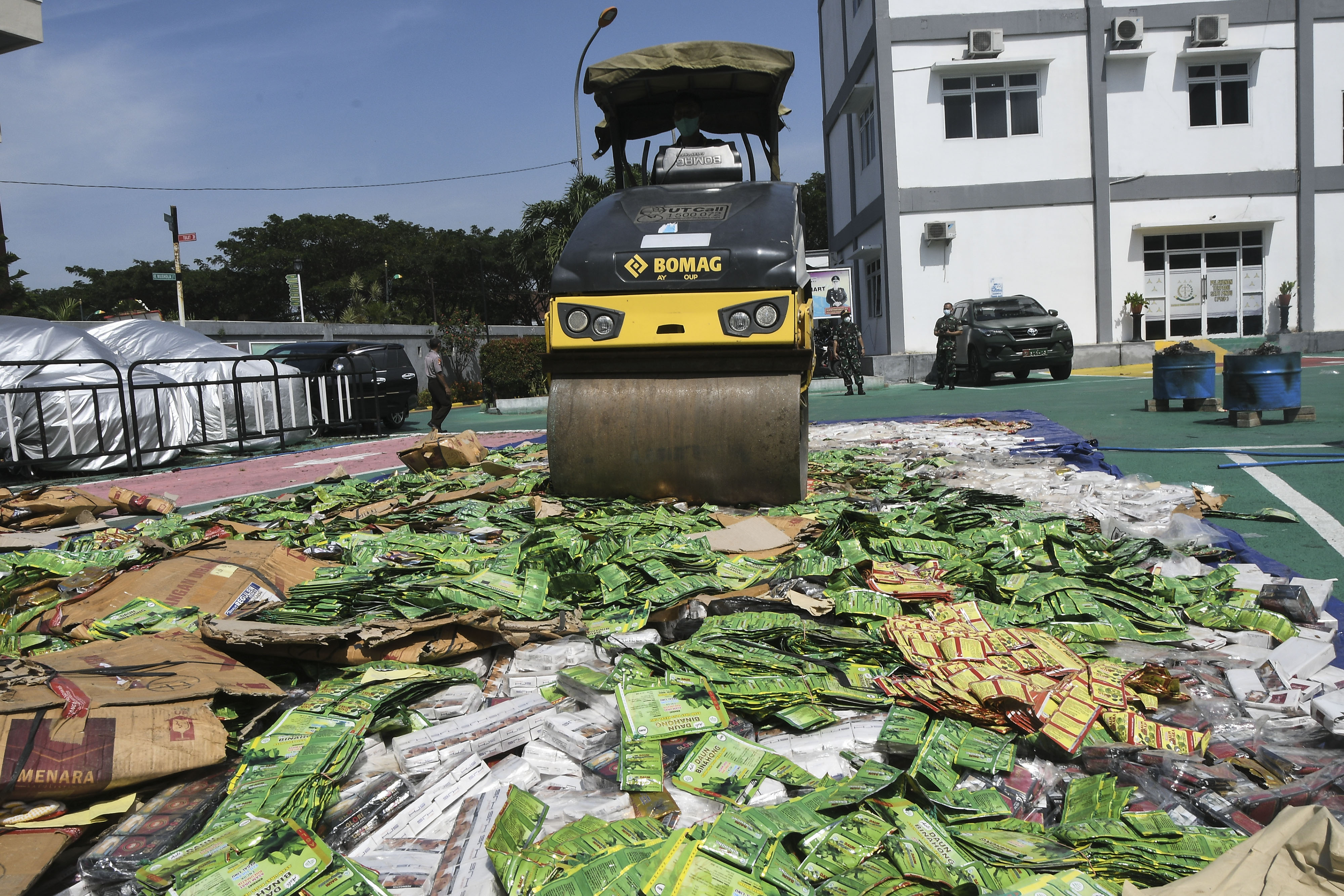 Petugas menggunakan alat berat memusnahkan barang bukti obat-obatan palsu hasil tindak pidana