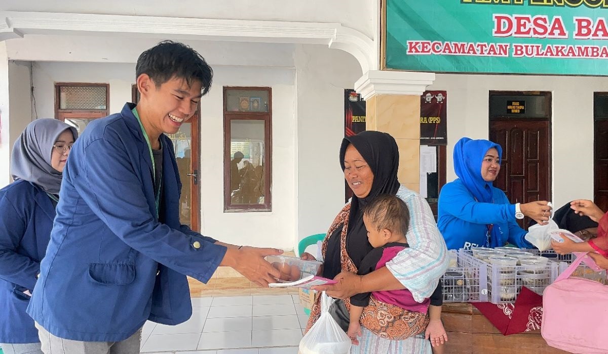 Mahasiswa KKN-T IPB University Christo Glory memberikan abon telur kepada seorang ibu.