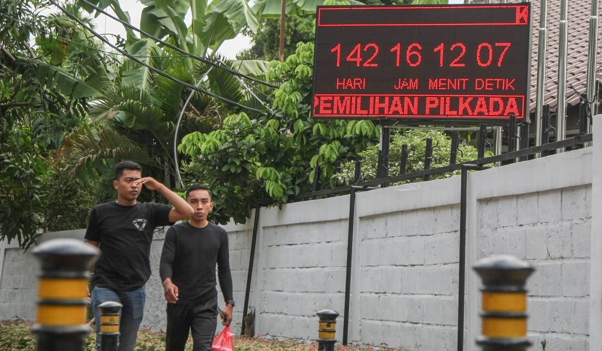 Warga melintas di dekat layar elektronik hitung mundur menuju Pilkada Serentak 2024 di depan kantor KPU Jakarta Pusat, Gambir, Jakarta.