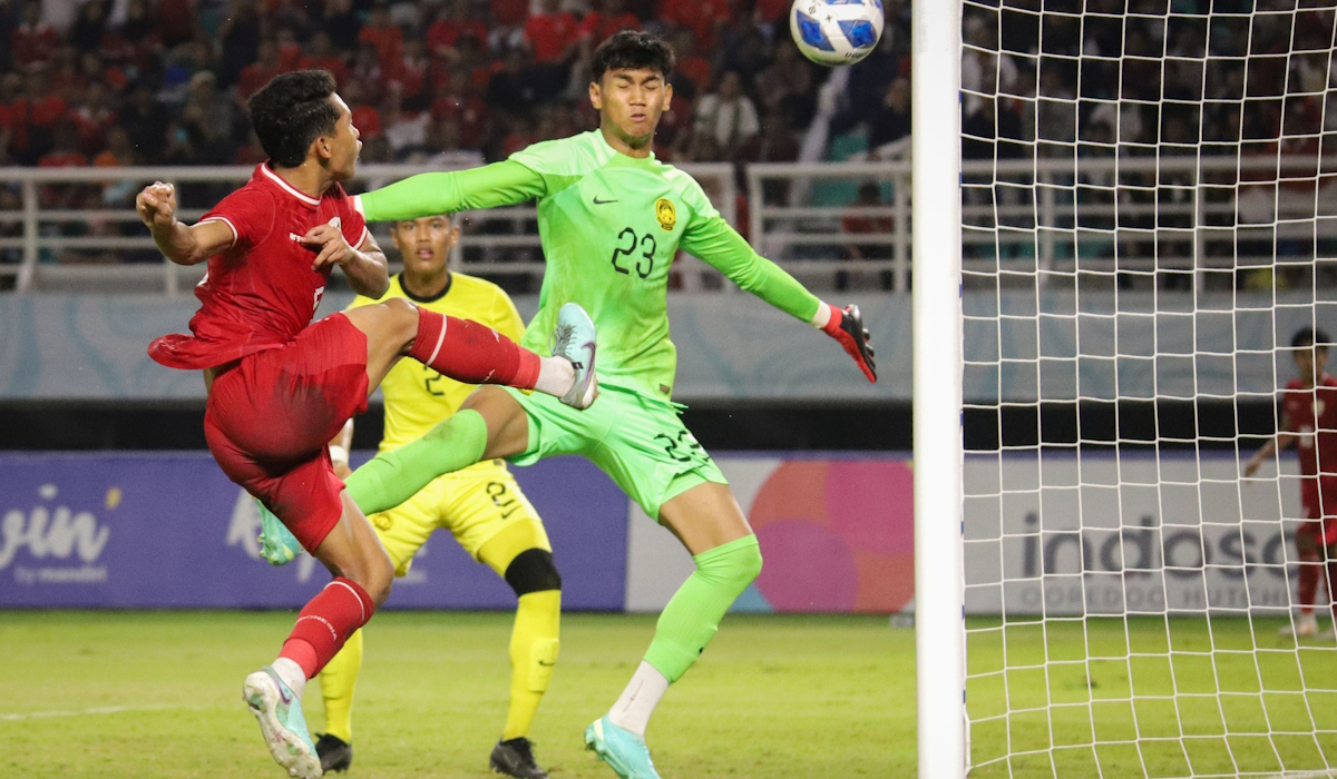Pesepak bola Timnas Indonesia Muhammad Alfharezzi Buffon (kiri) berusaha menjebol gawang kiper Timnas Malaysia