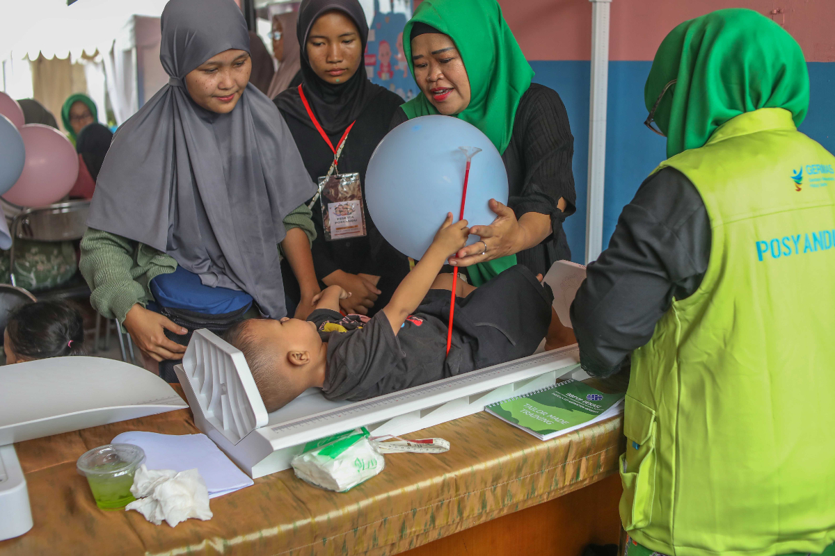 Para orang tua menimbangkan balitanya di Pos Pelayanan Terpadu (Posyandu) terintegrasi di RPTRA Taman Sawo, Jakarta