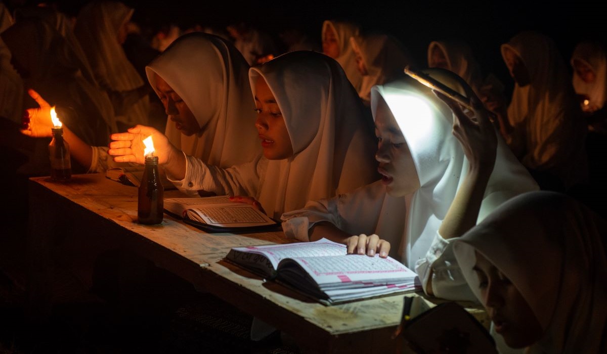 Sejumlah santri membaca Al-Qur'an dengan penerangan sentir di Pondok Pesantren Nurul Hidayah Al Mubarokah, Andong, Boyolali, Jawa Tengah.