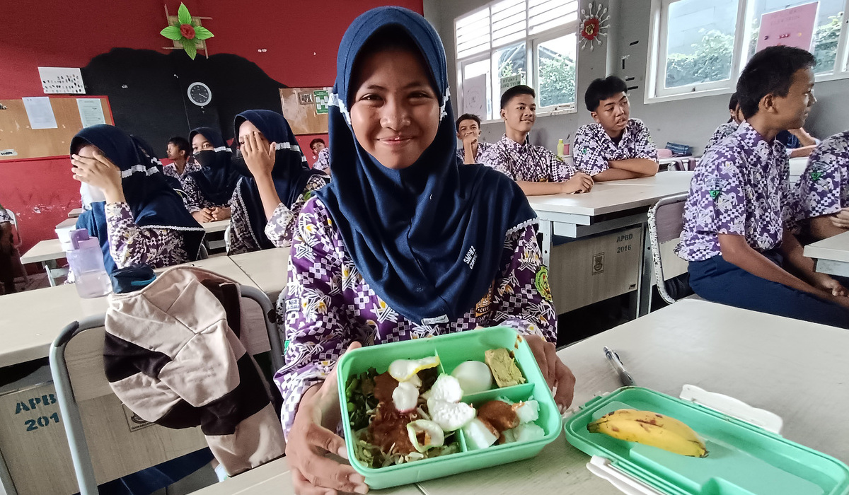 Siswa menunjukkan menu makan dalam simulasi makan siang gratis di SMP Negeri 2 Curug, Tangerang.