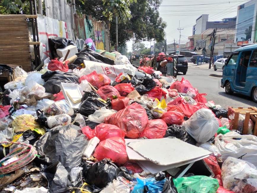 Tumpukan sampah meluber ke tengah Jalan Raya Bogor Depok
