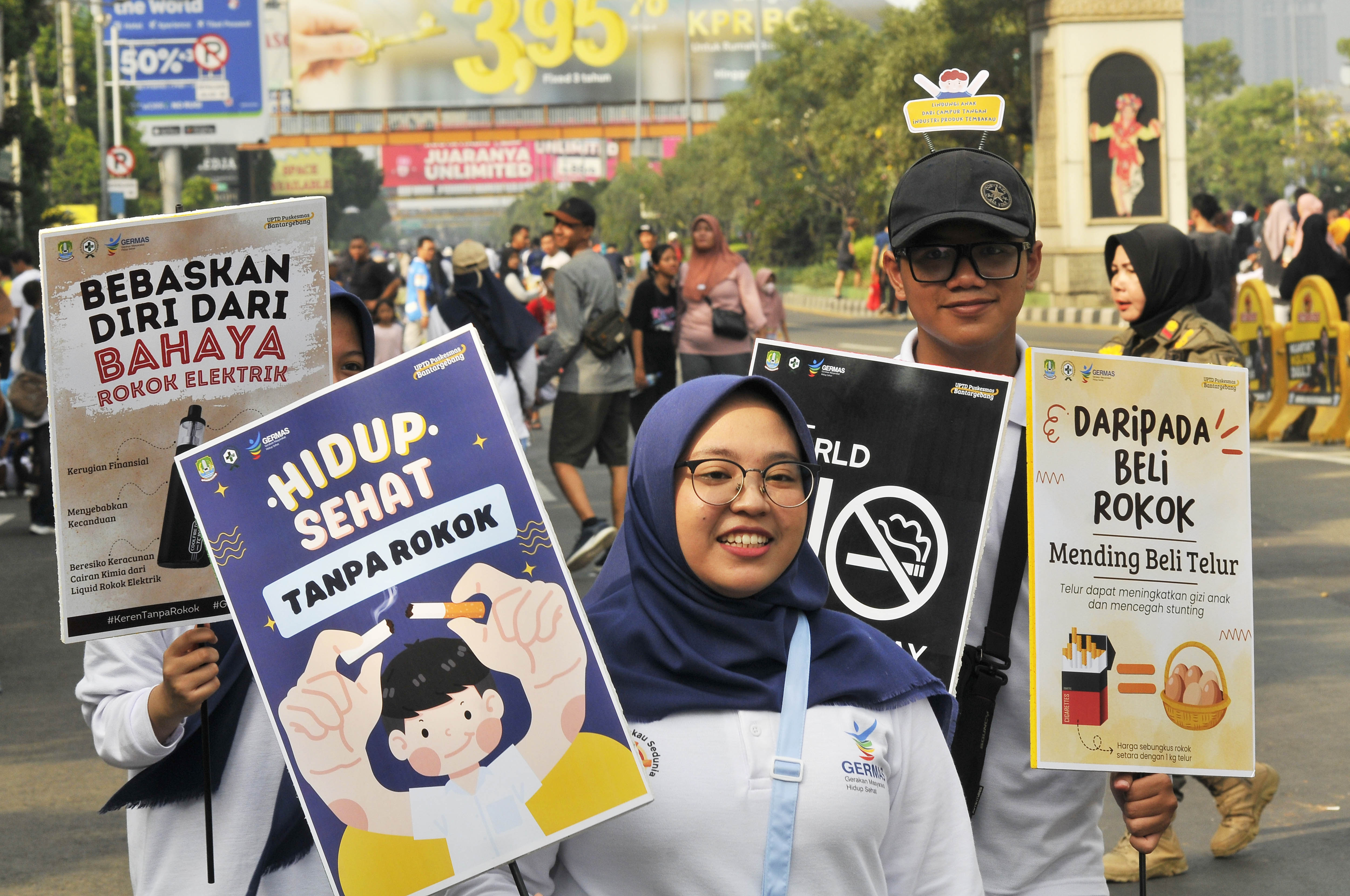 Sejumlah warga memegang poster sosialisasi dampak negatif dari mengkonsumsi rokok