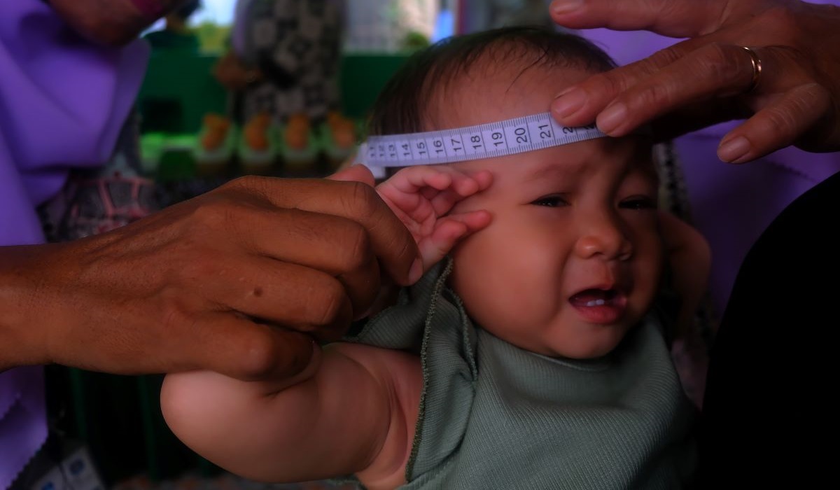 Pengukuran lingkar kepala bayi saat posyandu serentak di Posyandu Griya Mekar Delima di Sungai Raya Dalam, Kubu Raya, Kalbar.