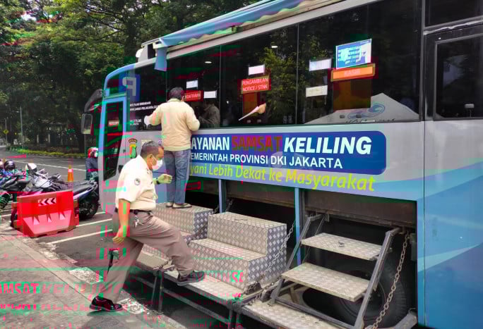 Warga mengurus perpanjangan surat kendaraan bermotor di kendaraan layanan Samsat Keliling di Gambir, Jakarta Pusat.
