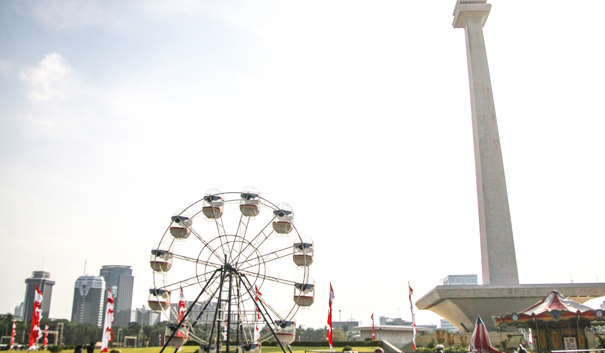 Pekerja tengah merangkai wahana hiburan rakyat di area Pasar Malam di Silang Monas, Jakarta,