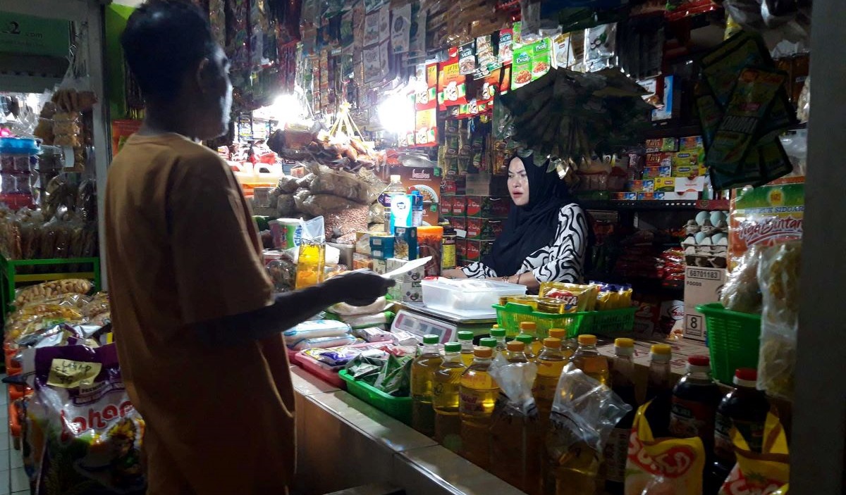 Pedagang bahan pokok di Pasar Dinoyo dan Pasar Blimbing, Kota Malang, Jawa Timur, menunggu pembeli.