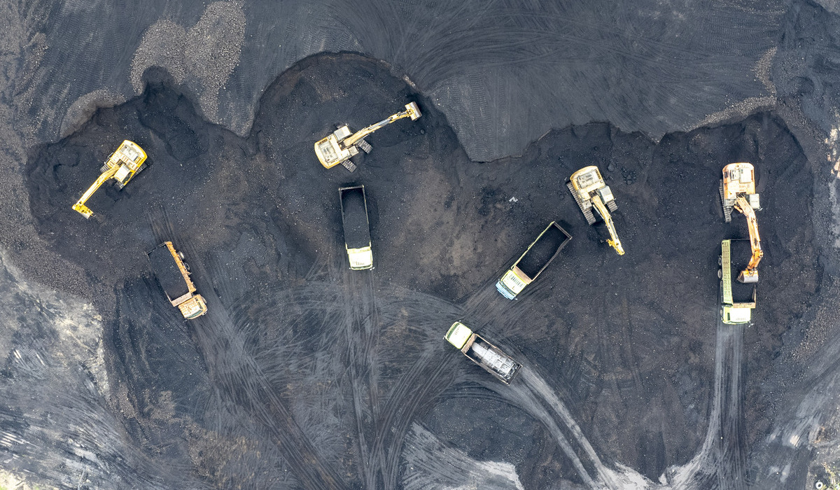 Foto udara alat berat memuat batu bara di tempat penampungan batu bara, tepi Sungai Batanghari, Muaro Jambi, Jambi.