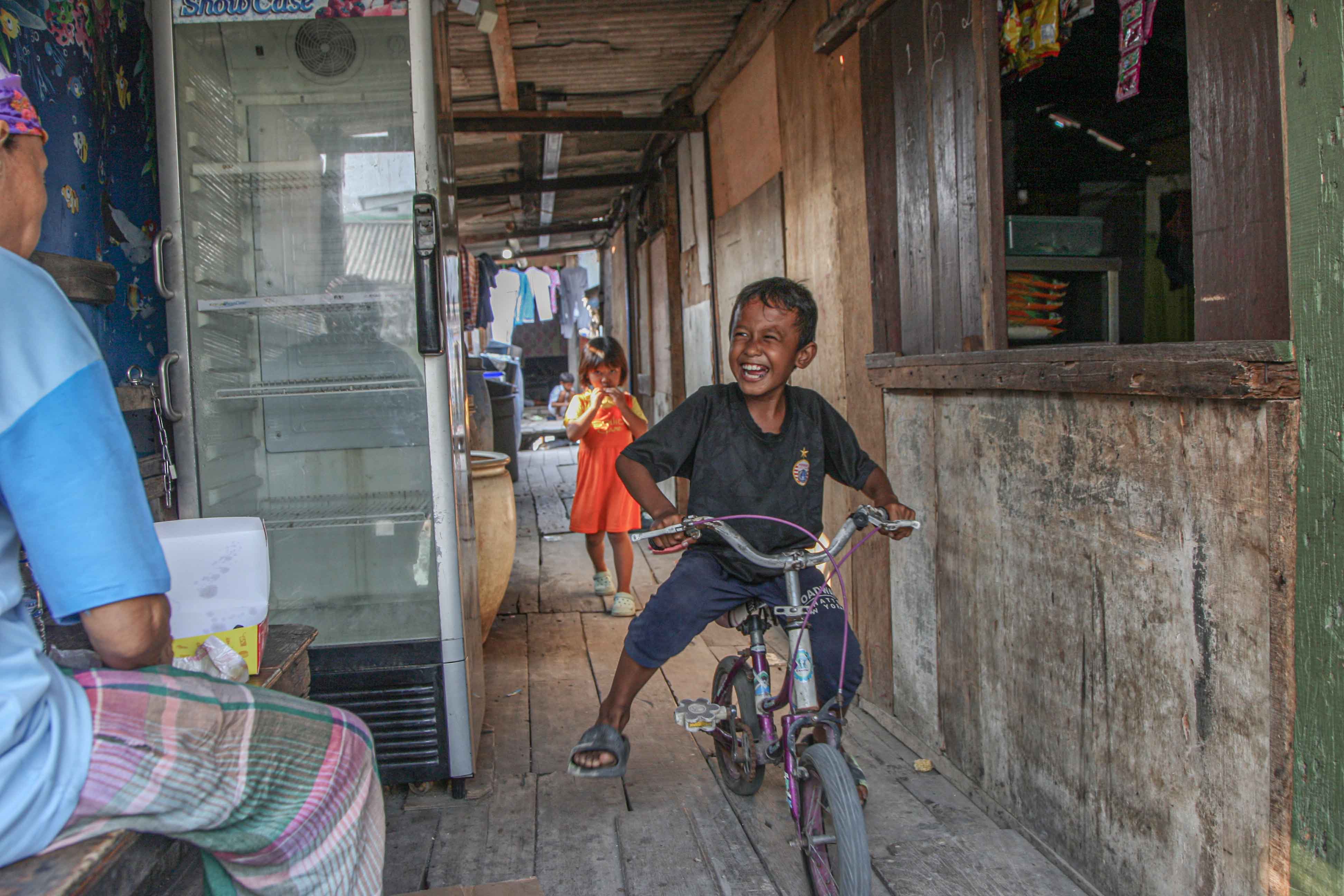 Anak-anak bermain di antara rumah-rumah gubug di kawasan Kampung Apung, Muara Baru, Jakarta Utara