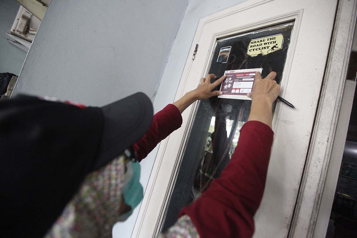  Petugas Pemutakhiran Daftar Pemilih (Pantarlih) Juarsih menempel stiker usai melakukan pencocokan dan penelitian (Coklit) data pemilih.