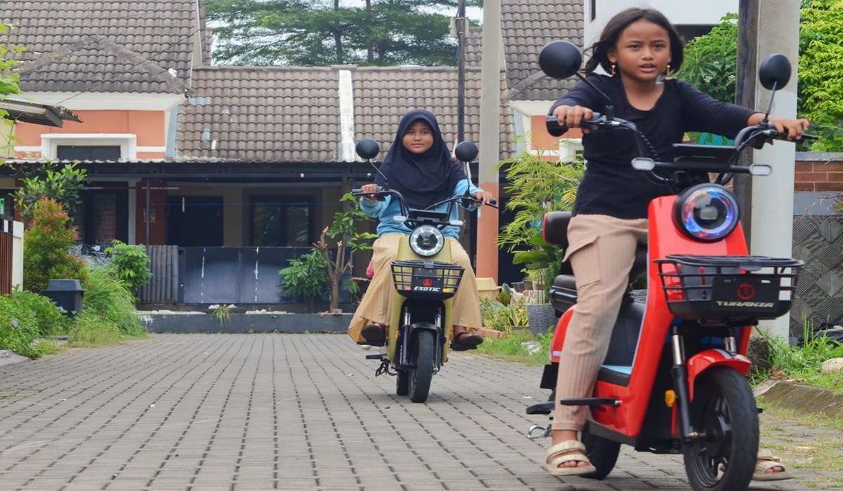 Anak-anak tengah bermain dengan mengendarai sepeda motor listrik di komplek perumahan di Jakarta.