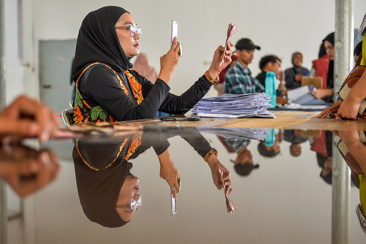 Petugas memotret warga yang telah menerima bantuan sosial program keluarga harapan (PKH) di Kantor Pos Cabang Utama, Bandung, Jawa Barat.
