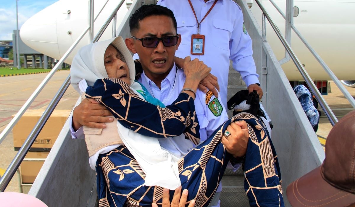 Petugas menggendong seorang jemaah haji lansia asal Kalimantan Barat saat tiba di Bandara Supadio, Kabupaten Kubu Raya, Kalimantan Barat.