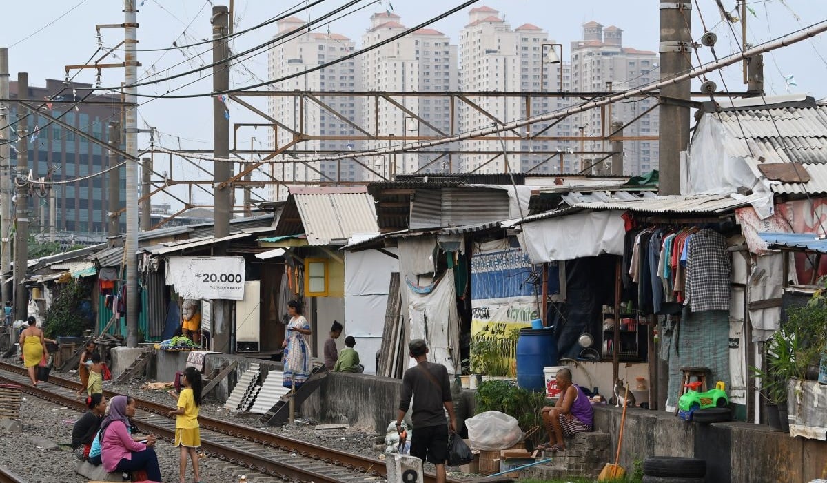 Sejumlah warga beraktivitas di perkampungan padat penduduk tepi rel kereta api di Kampung Bandan, Jakarta, Jumat (14/10/2022). Badan Pusat S