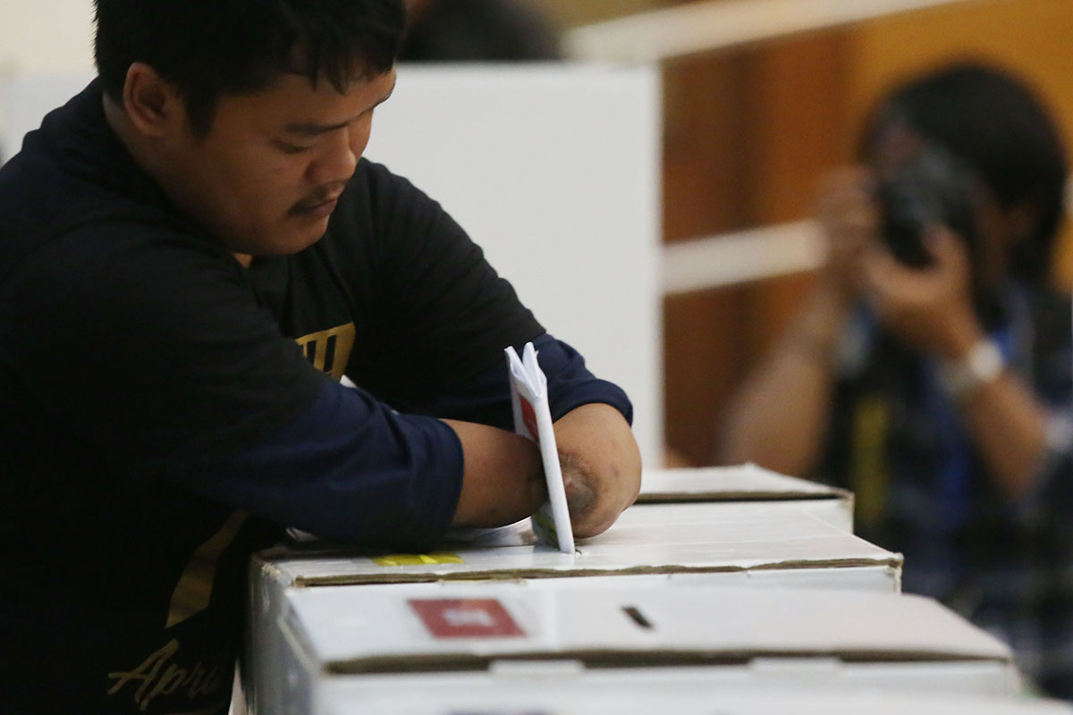  Penyandang disabilitas memasukkan surat suara yang telah dicoblos ke dalam kotak suara saat sosialisasi pendidikan pemilih.