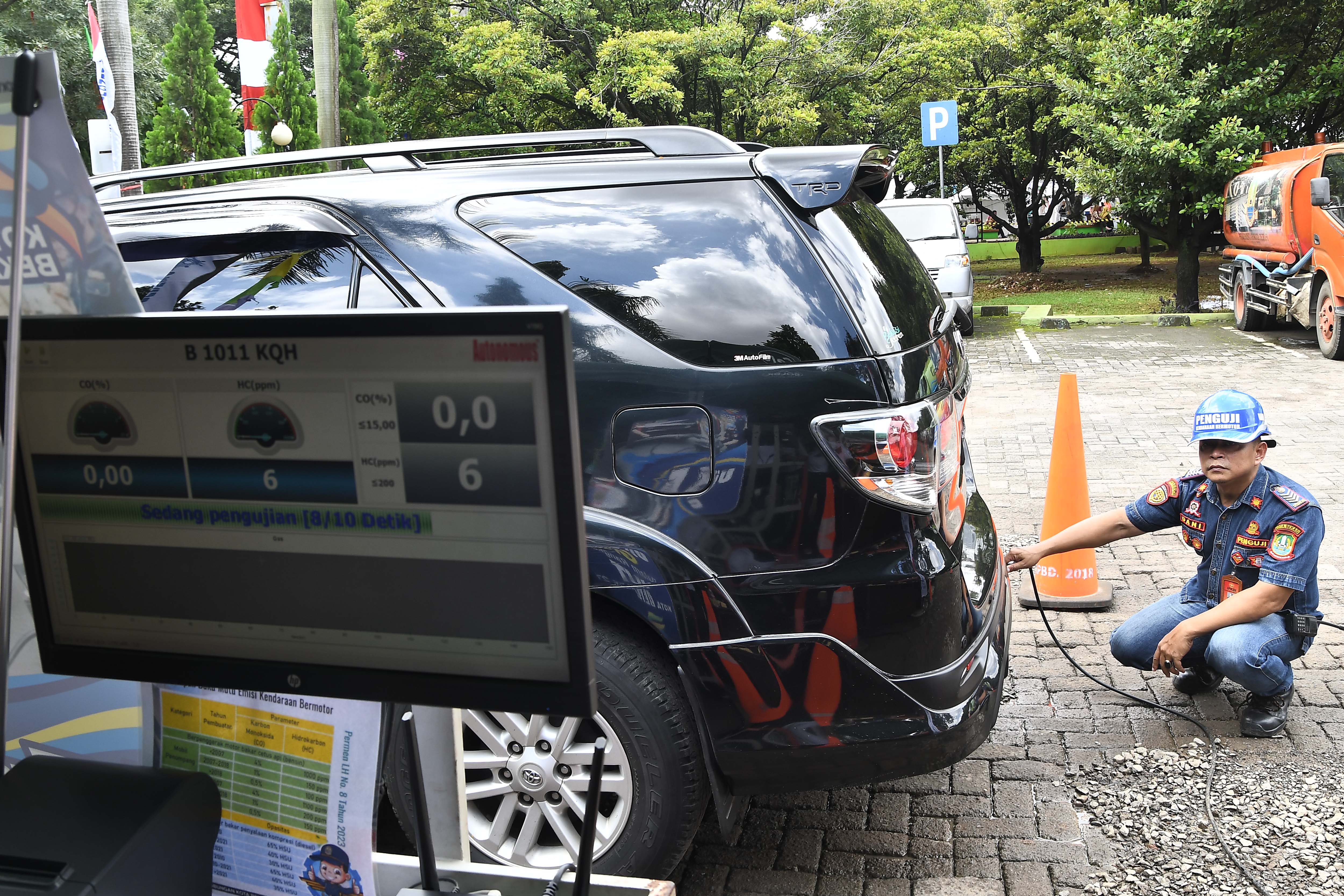 Petugas melakukan uji emisi kendaraan gratis
