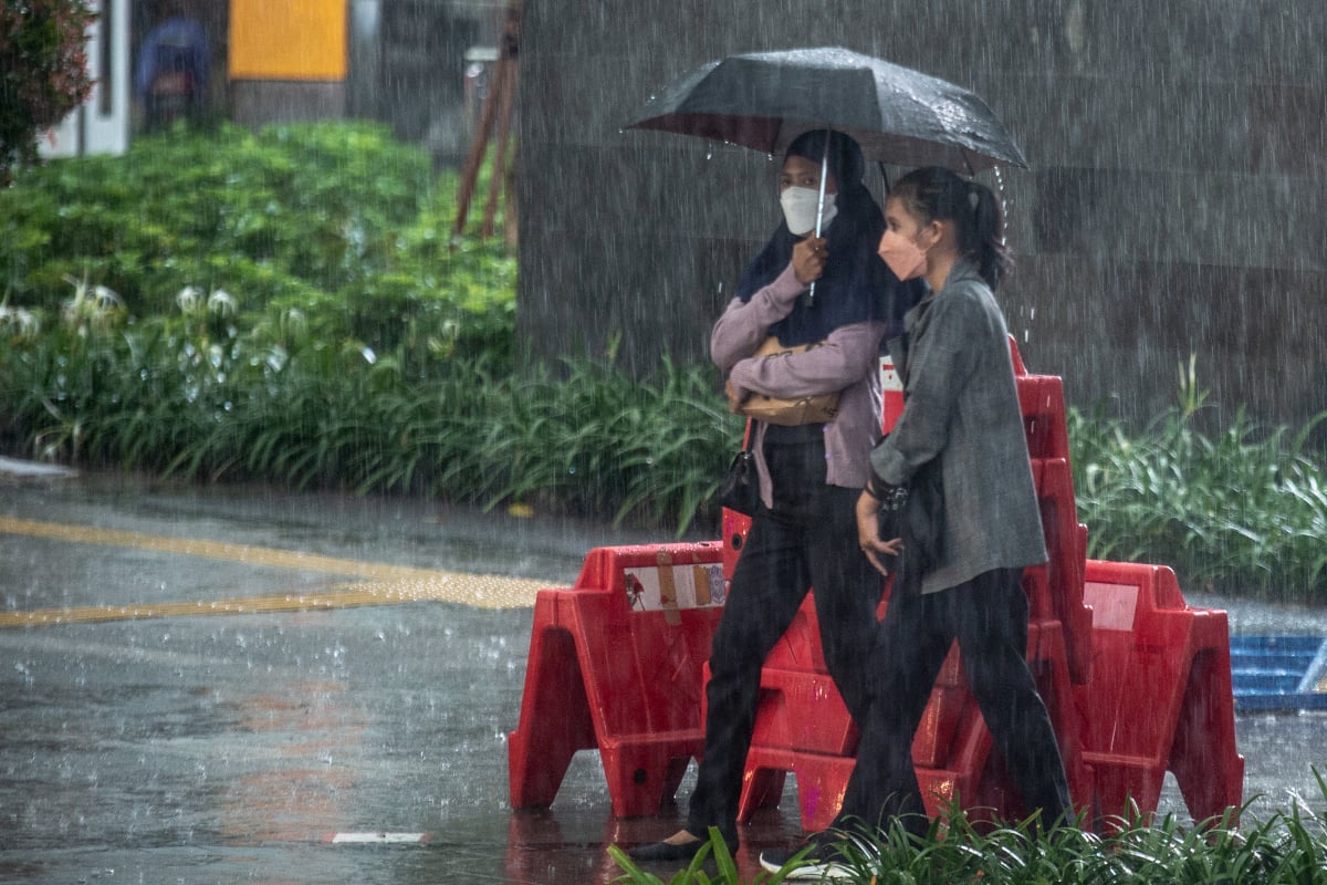 Warga berjalan menggunakan payung saat hujan lebat di kawasan Sarinah Thamrin, Jakarta