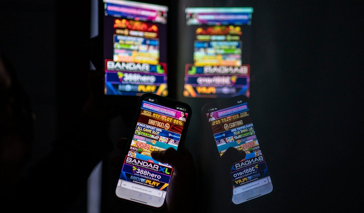 Warga melihat iklan judi online melalui gawainya 