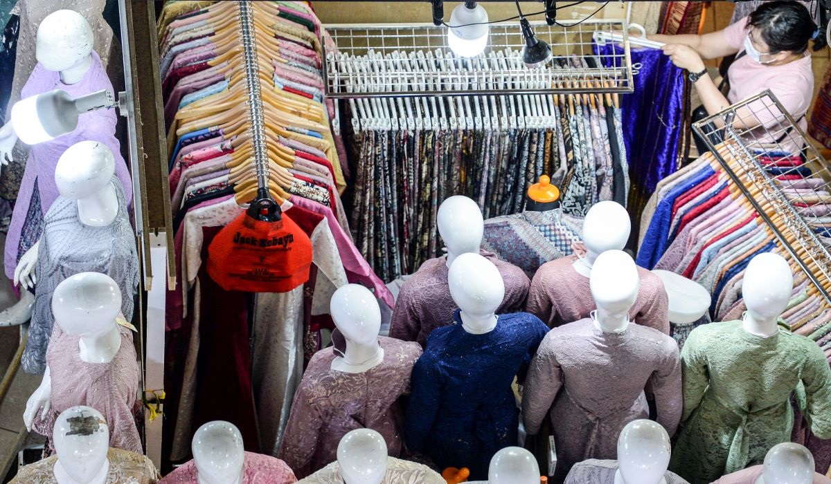 Seorang pedagang mempersiapkan dagangannya di pusat perbelanjaan di Jakarta, Selasa (14/12/2021).