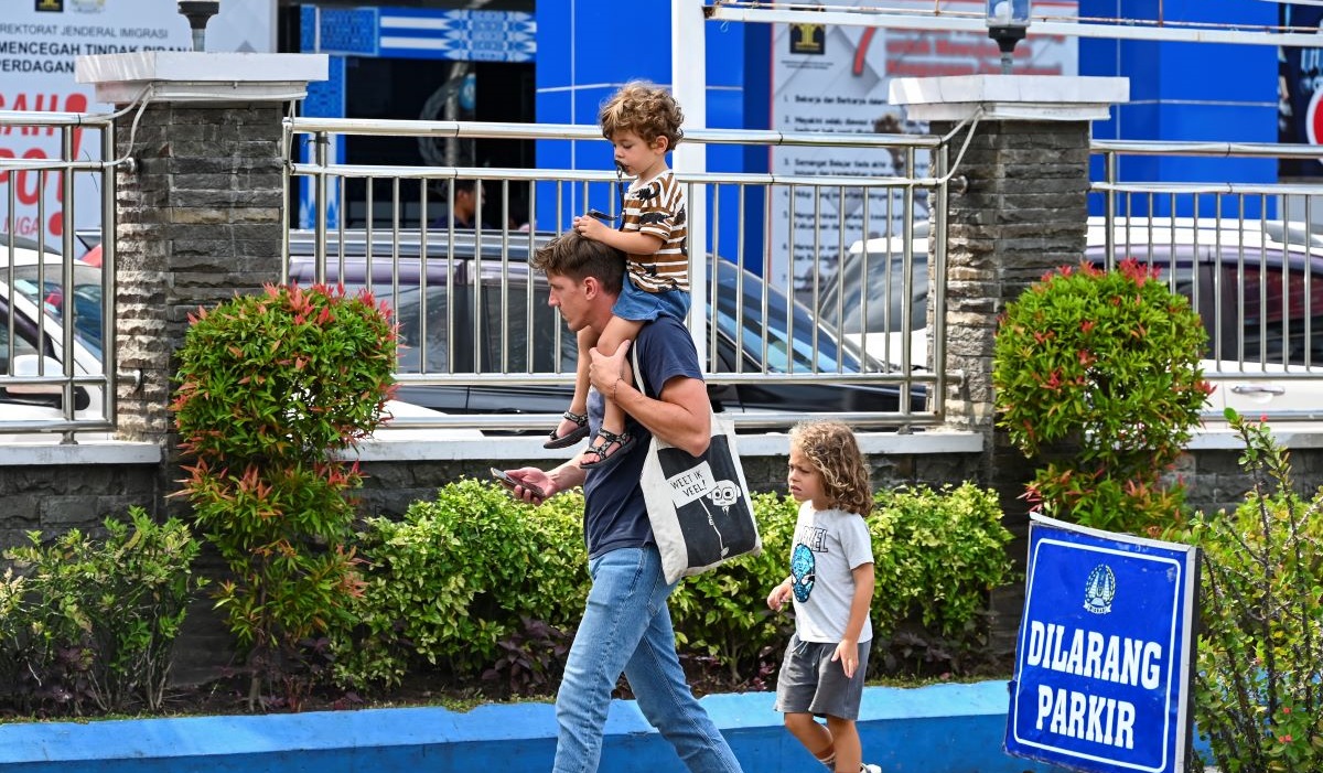 Seorang warga negara asing bersama anaknya berjalan menuju kantor Imigrasi Kelas I Mataram di Mataram, NTB, Senin (11/9/2023).