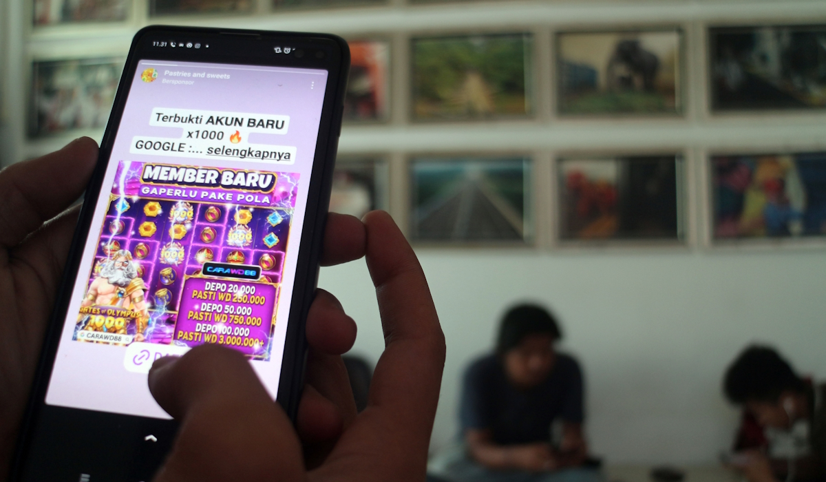 Ilustrasi: warga melihat iklan judi online melalui gawainya