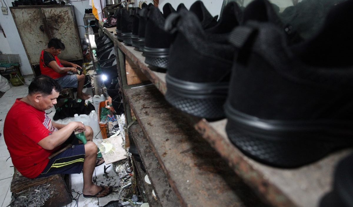 Pekerja membuat sepatu sekolah di salah satu industri rumahan di Gubeng Jaya, Surabaya, Jawa Timur, Rabu (10/7/2024).