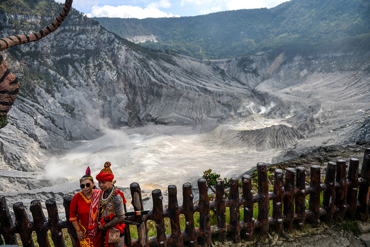 Wisatawan berfoto dengan latar belakang Kawah Ratu di Taman Wisata Alam Gunung Tangkuban Parahu, Subang, Jawa Barat, Minggu (23/6).