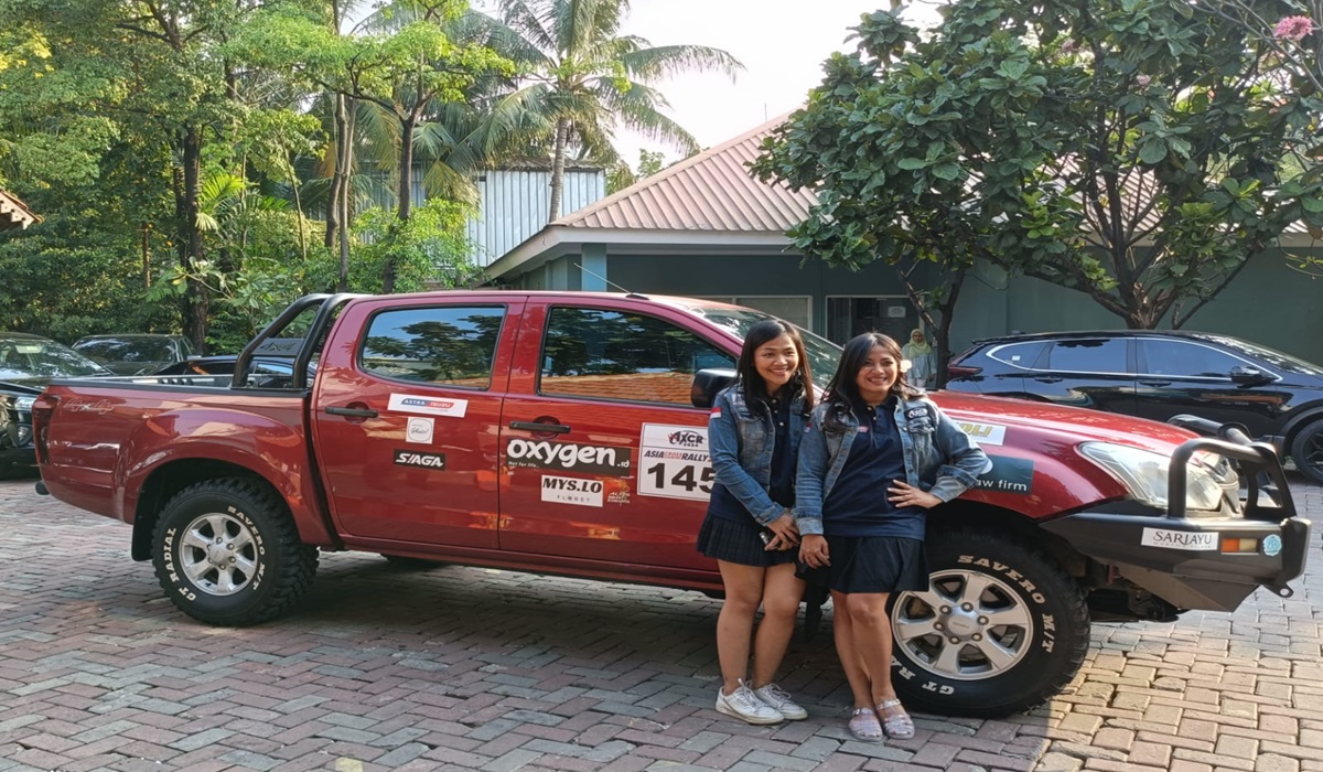 Pereli Lody Natasha dan Sasty Laksamana berdiri di depan mobil yang akan mereka gunakan di Asia Cross Country Rally.