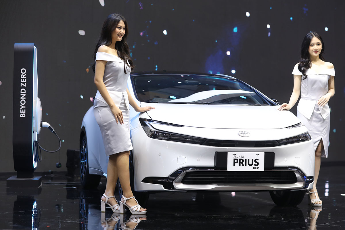Model berfoto dengan mobil All New Prius Hybrid Electric Vehicle (HEV).