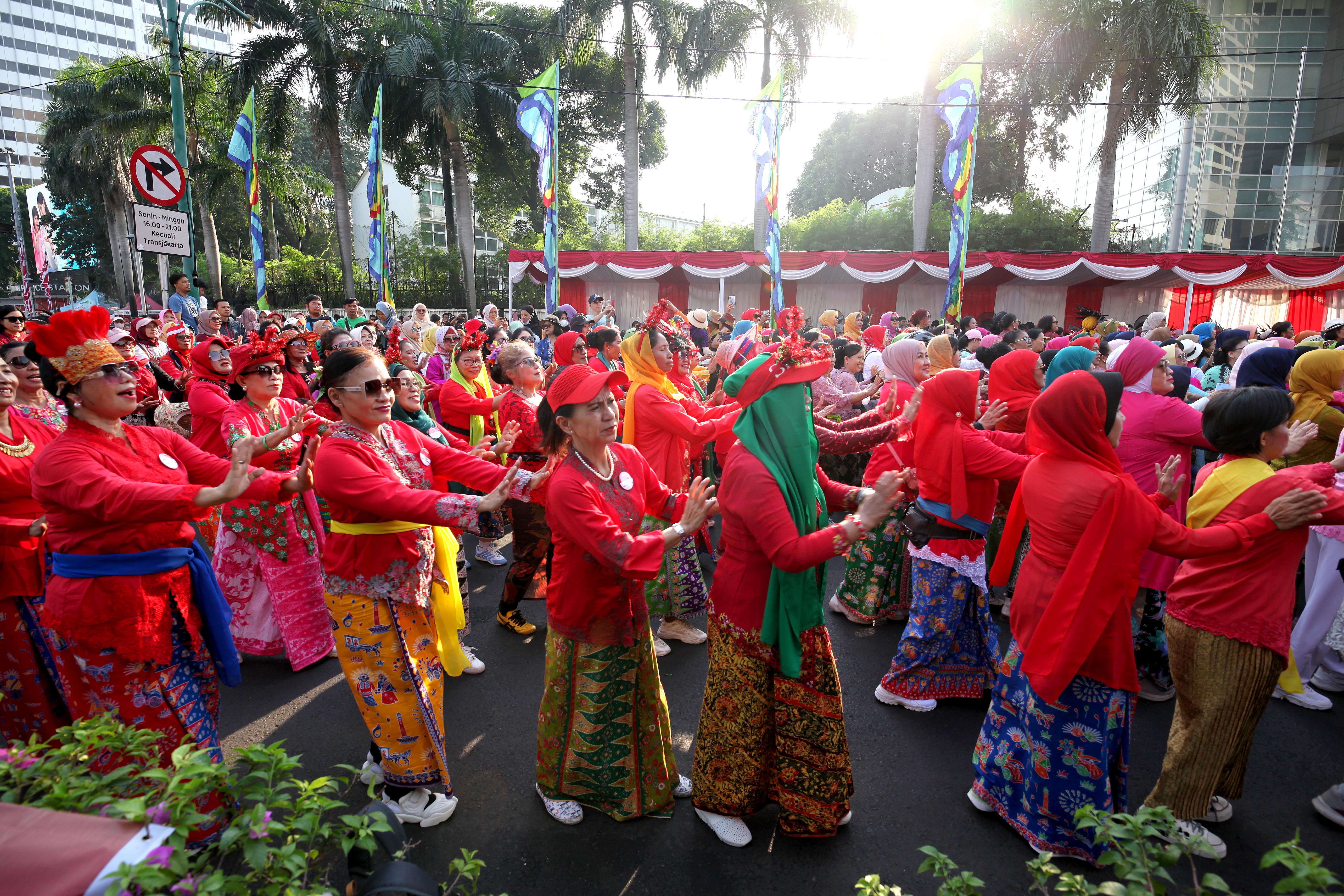 Para perempuan memakai gaun kebaya menggelar tarian flasmob bersama kelompok perempuan lainnya di bundaran HI, Jakarta, Minggu (14/7/2024).