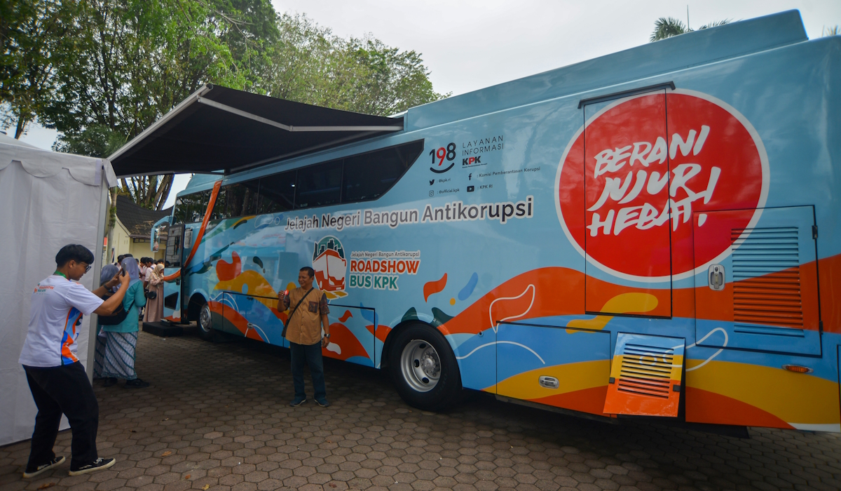 Pengunjung berfoto di depan bus saat Roadshow Bus Komisi Pemberantasan Korupsi (KPK) 