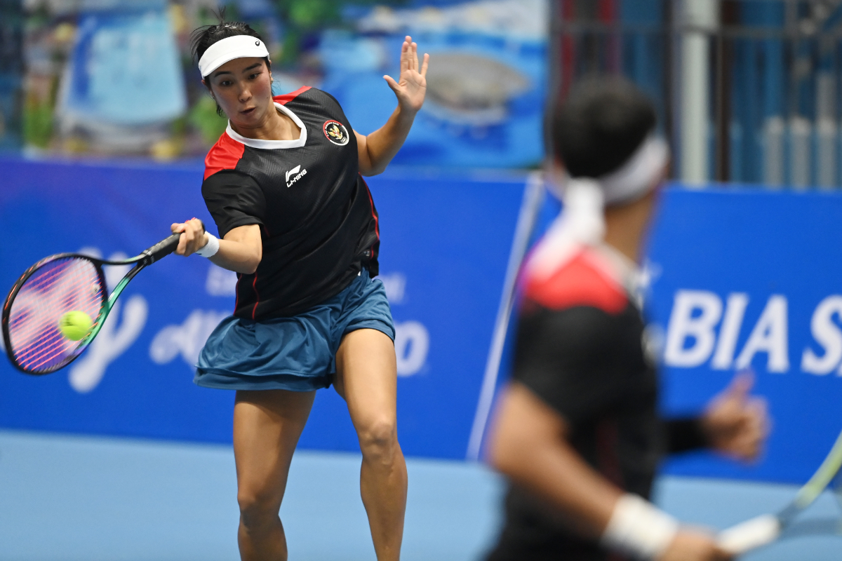 Petenis Indonesia Aldila Sutjiadi (kiri) dengan disaksikan pasangannya dalam tim, Christopher Rungkat (kanan) memukul bola ke arah lawannya 