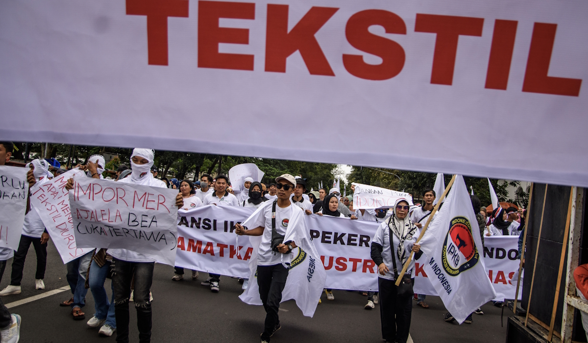 Massa yang tergabung dalam Aliansi IKM dan Pekerja Tekstil Indonesia berunjuk rasa di depan Gedung Sate 