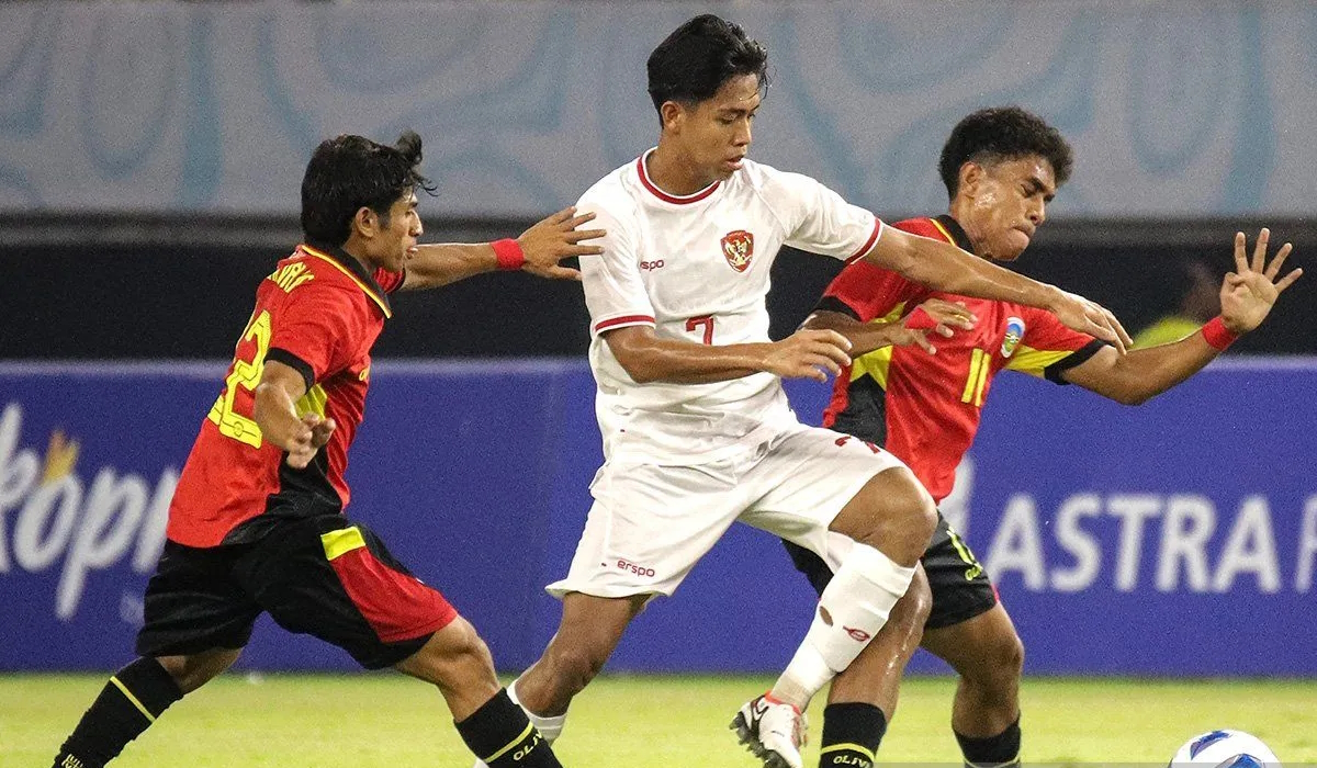 Pesepak bola Timnas Indonesia Figo Dennis Saputrananto (tengah) berebut bola dengan dua pesepak bola Timnas Timor Leste
