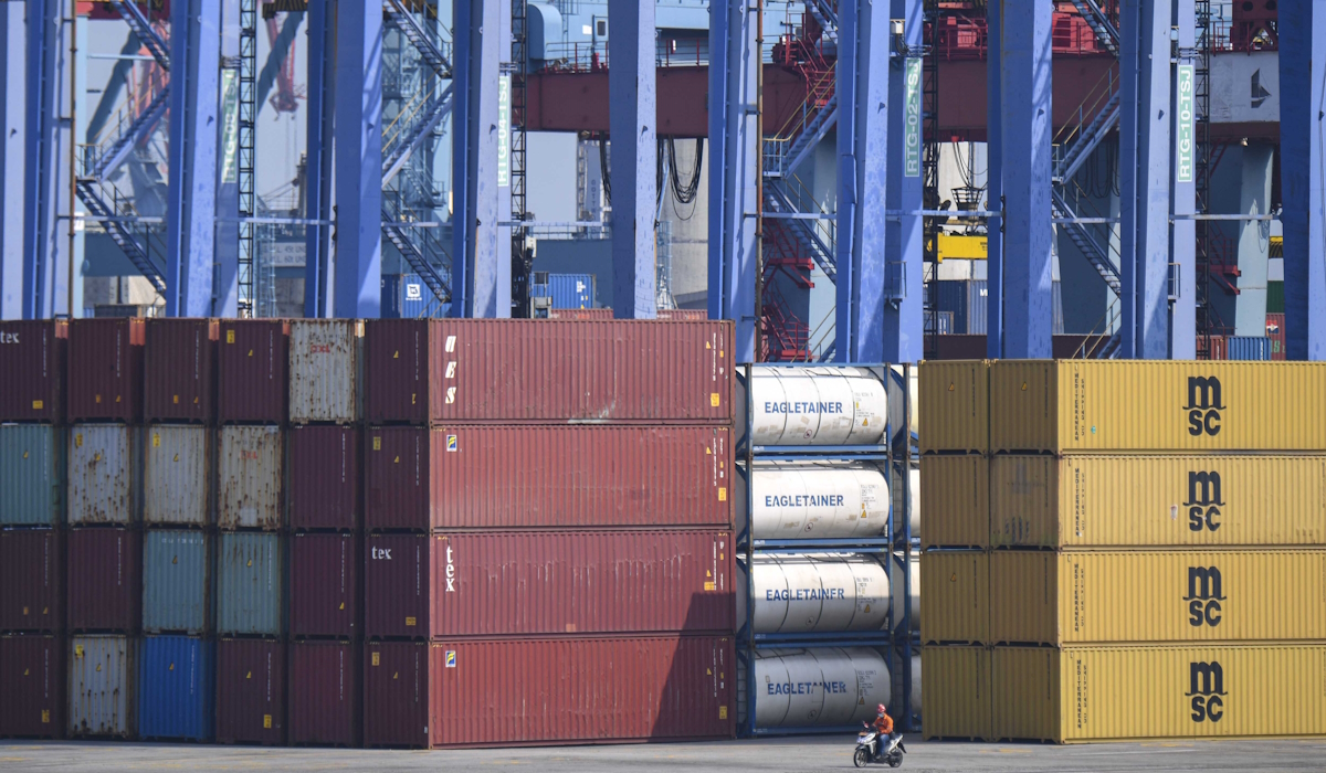 Ilustrasi: Seorang petugas mengendarai sepeda motor melintas di samping peti kemas di Pelabuhan Tanjung Priok, Jakarta