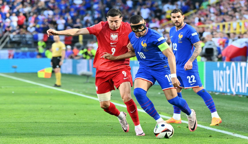 Penyerang timnas Prancis Kylian Mbappe (kanan) berduel dengan striker Polandia Robert Lewandowski di laga Euro 2024.