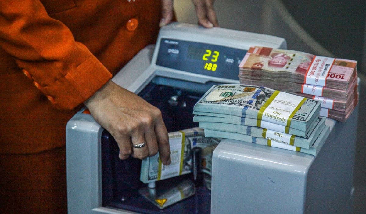 Petugas menghitung uang pecahan dolar AS dan rupiah di gerai jasa penukaran mata uang asing, ,Menteng, Jakarta Pusat, Kamis (20/6/2024).