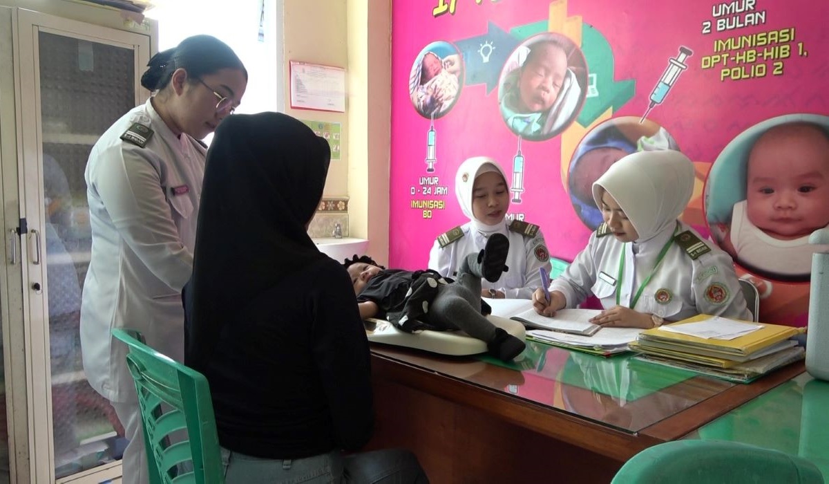 Seorang ibu membawa anaknya ke Puskesmas Pattingalloang, Kota Makassar, untuk mendapatkan imunisasi rutin.