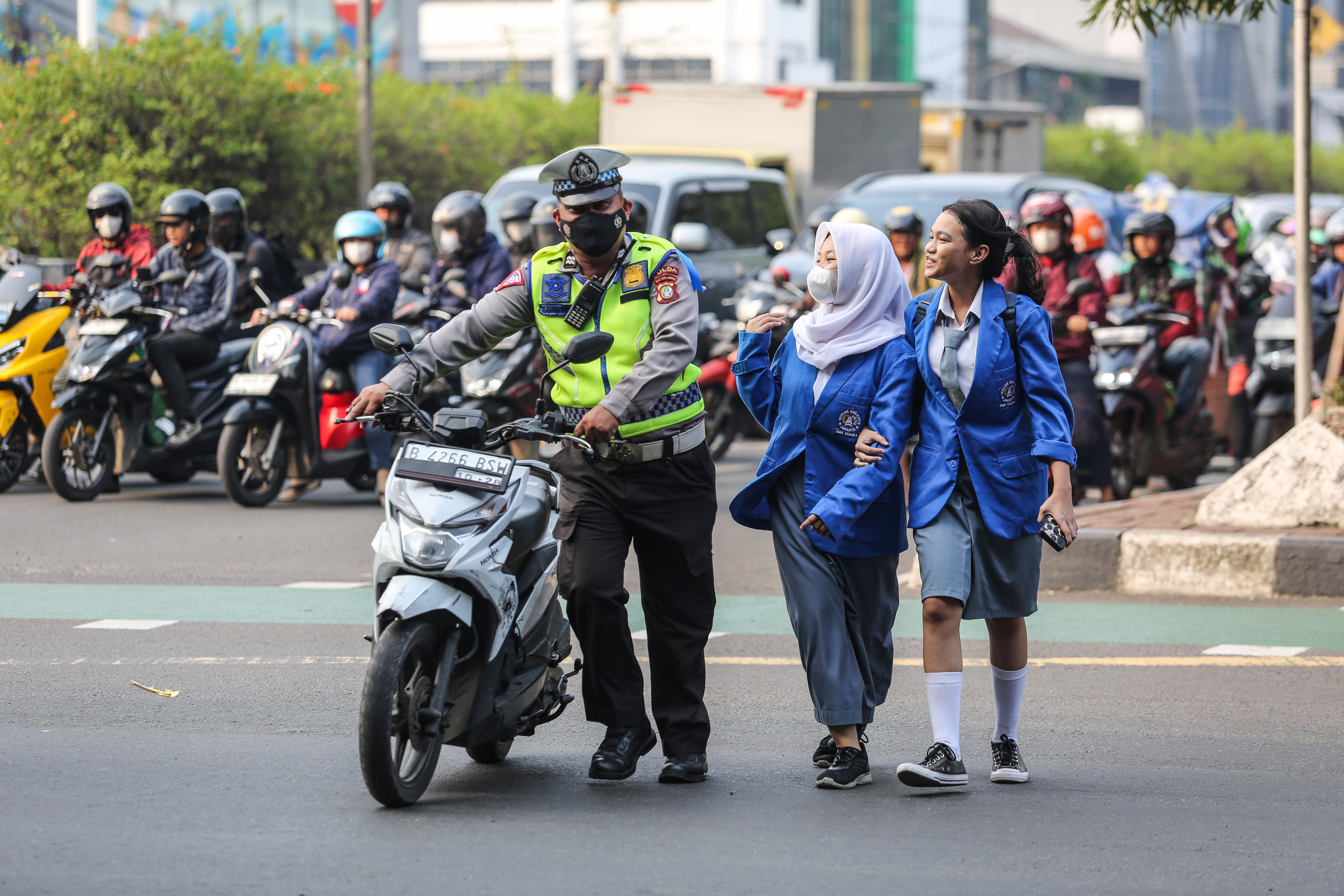 Anggota Polisi membawa motor pengendara yang melanggar aturan saat Operasi Patuh Jaya 2024 di Jl Letjen S Parman, Jakarta, Senin (15/7/2024)