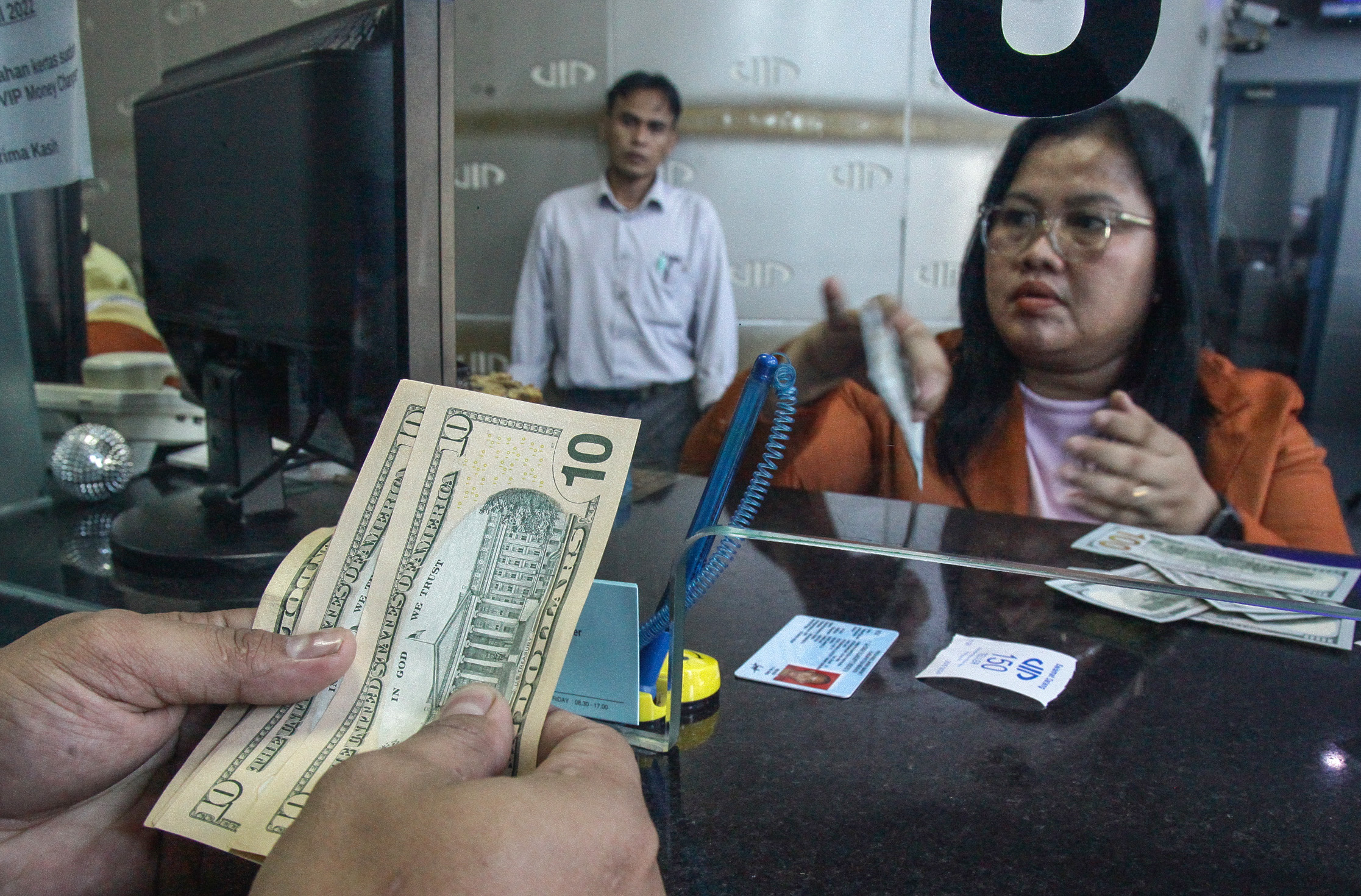 Petugas melayani penukaran uang dolar AS ke rupiah di money changer di Jakarta, Kamis (20/6).